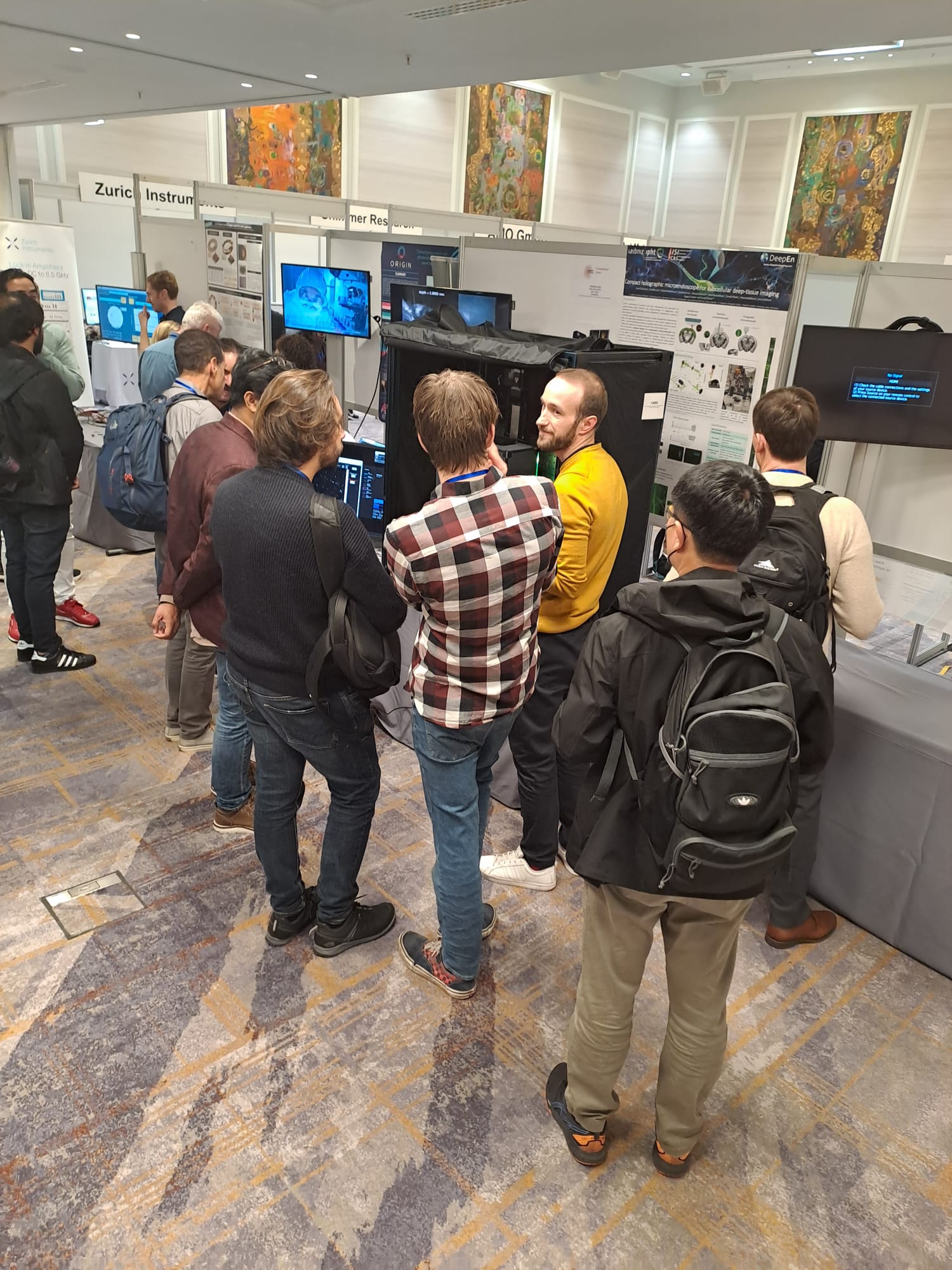 Researchers observing and discussing DeepEn One’s imaging performance during the IEEE Sensors 2023 demonstration in Vienna.