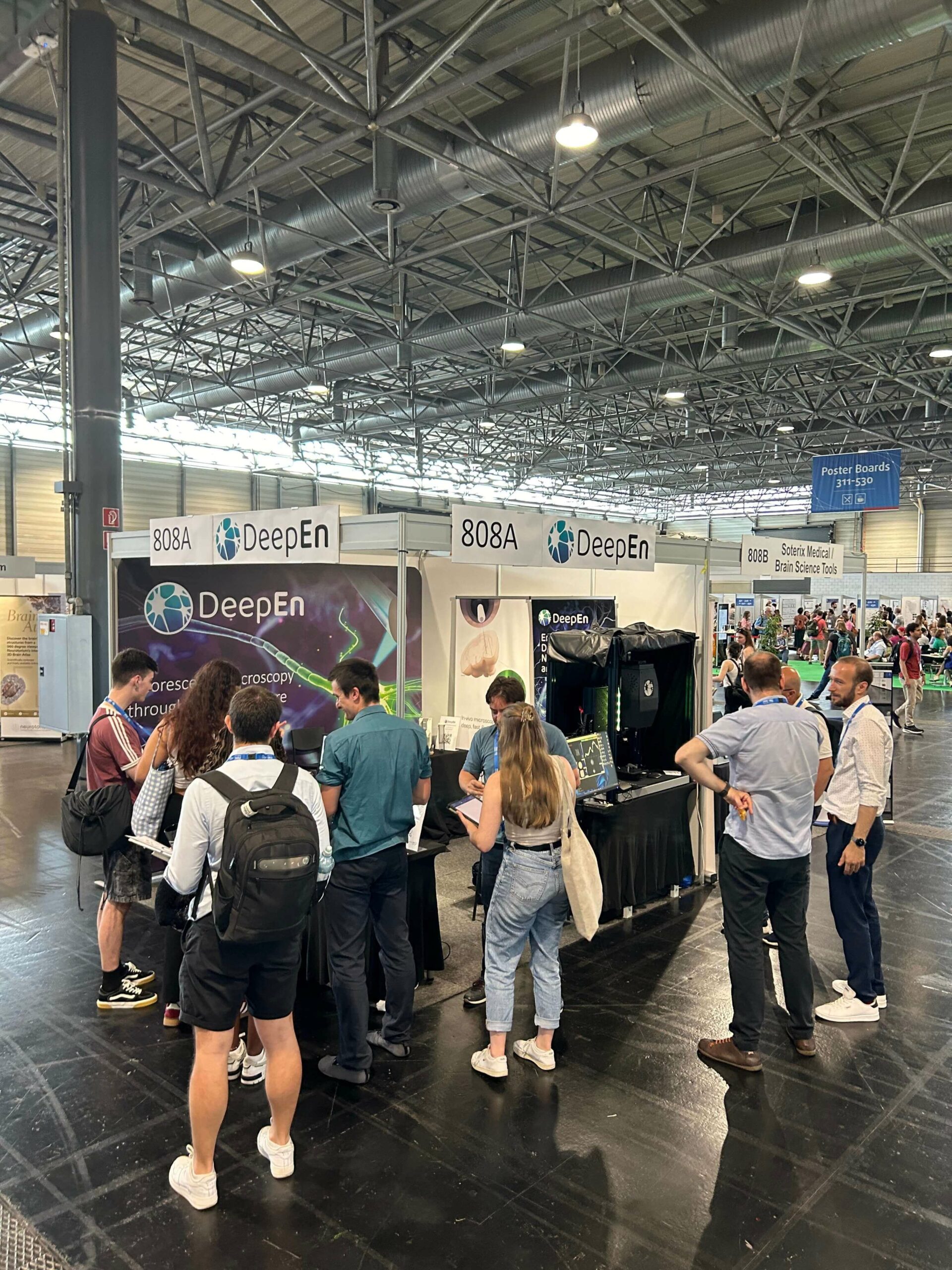 Visitors interacting with the DeepEn One endoscope demonstration at FENS 2024 in Vienna.